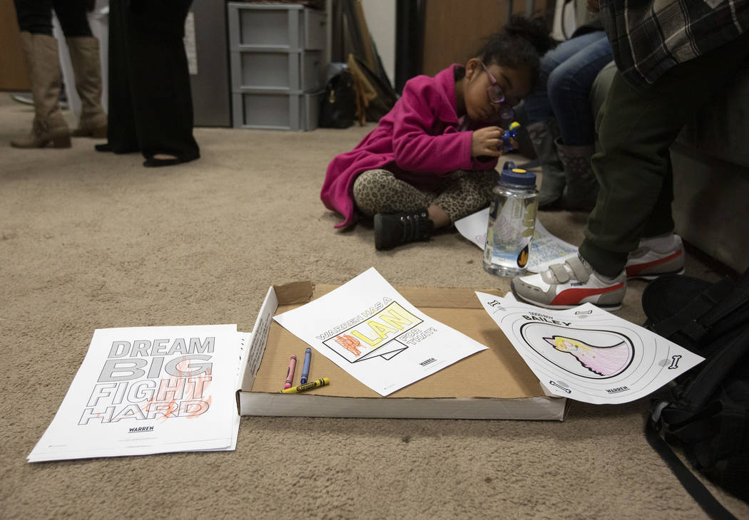 Natalie Guigui, 5, plays with toys after coloring Elizabeth Warren slogans at an organizing eve ...