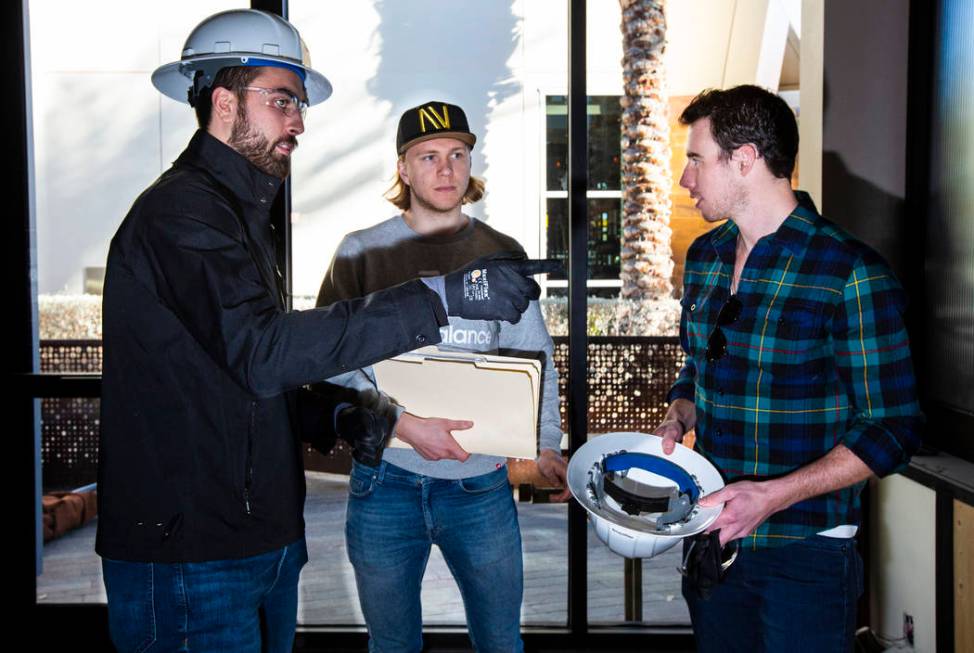 Golden Knights' Alex Tuch, left, talks with teammates William Karlsson, center, and Reilly Smit ...