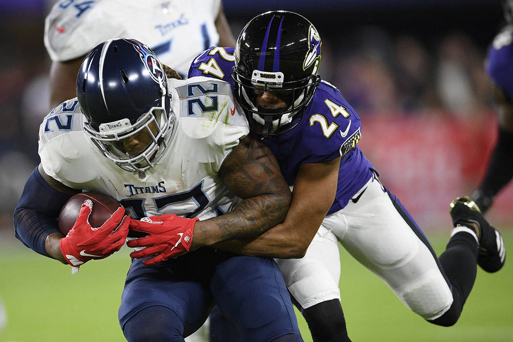 Baltimore Ravens cornerback Marcus Peters (24) hits Tennessee Titans running back Derrick Henry ...