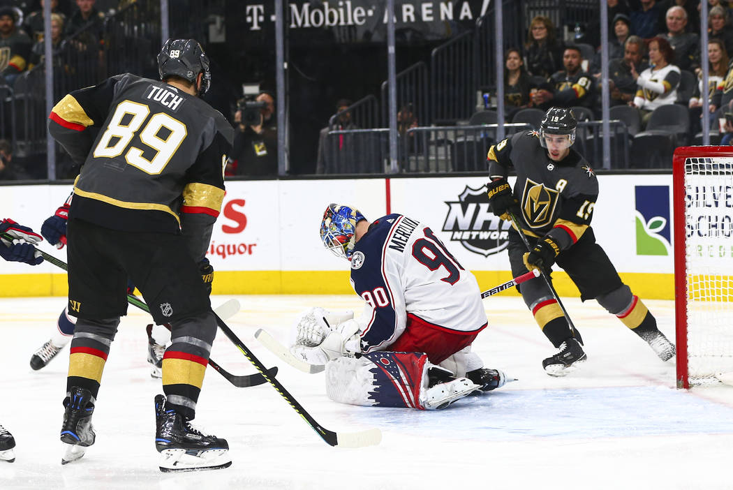 Columbus Blue Jackets goaltender Elvis Merzlikins (90) stops the puck between Golden Knights' A ...