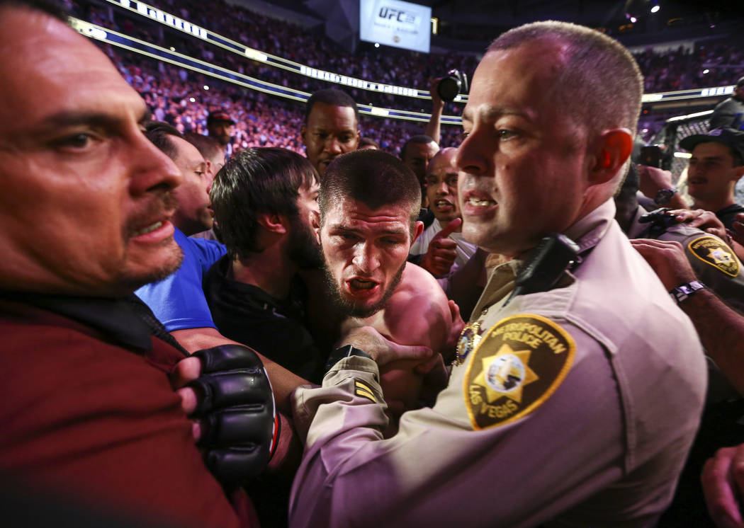 Fighter Khabib Nurmagomedov is held back by Las Vegas police and security following Nurmagomedo ...
