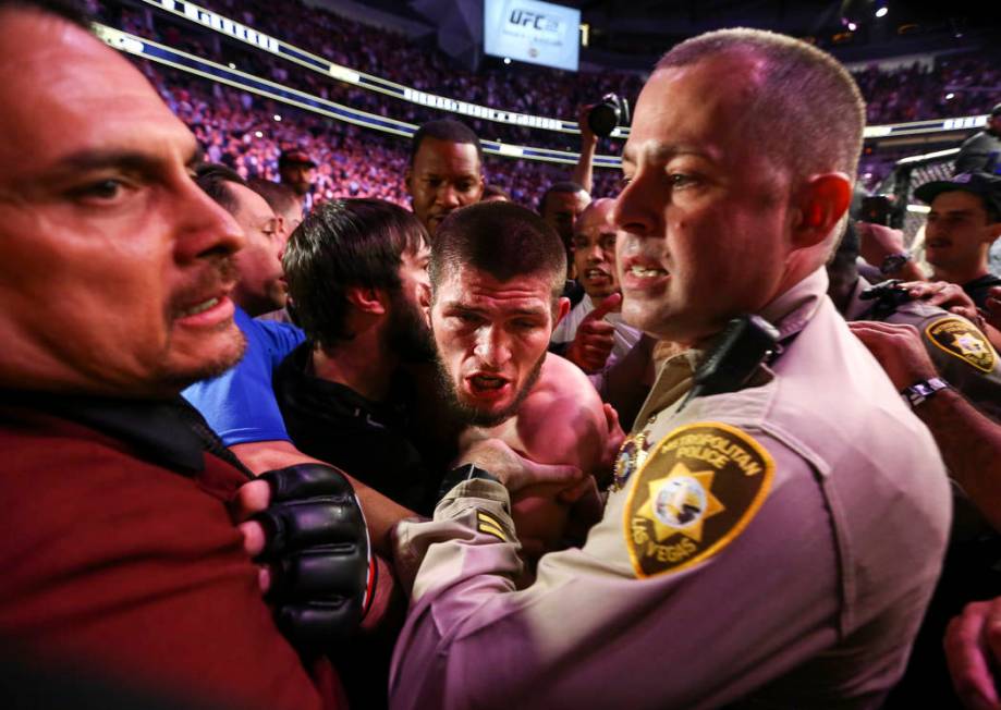 Fighter Khabib Nurmagomedov is held back by Las Vegas police and security following Nurmagomedo ...