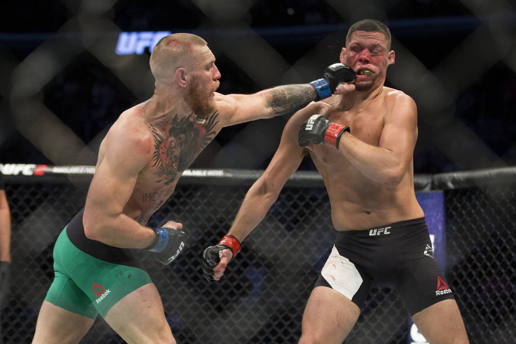 Conor McGregor, left, connects a left punch against Nate Diaz in the welterweight bout during U ...