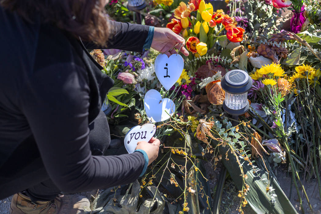 Ruth Neall organizes and puts fresh flowers on Monday, Jan. 13, 2020, at the memorial at the sp ...