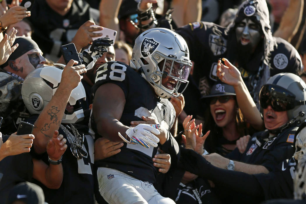 Oakland Raiders running back Josh Jacobs, center, celebrates with fans after scoring against th ...