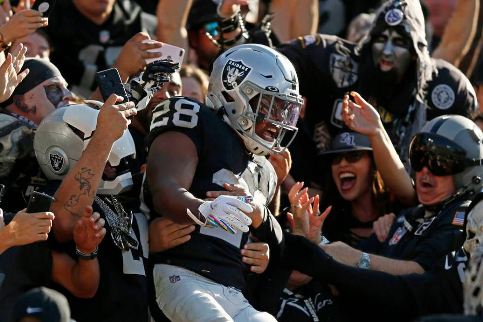 Oakland Raiders running back Josh Jacobs, center, celebrates with fans after scoring against th ...