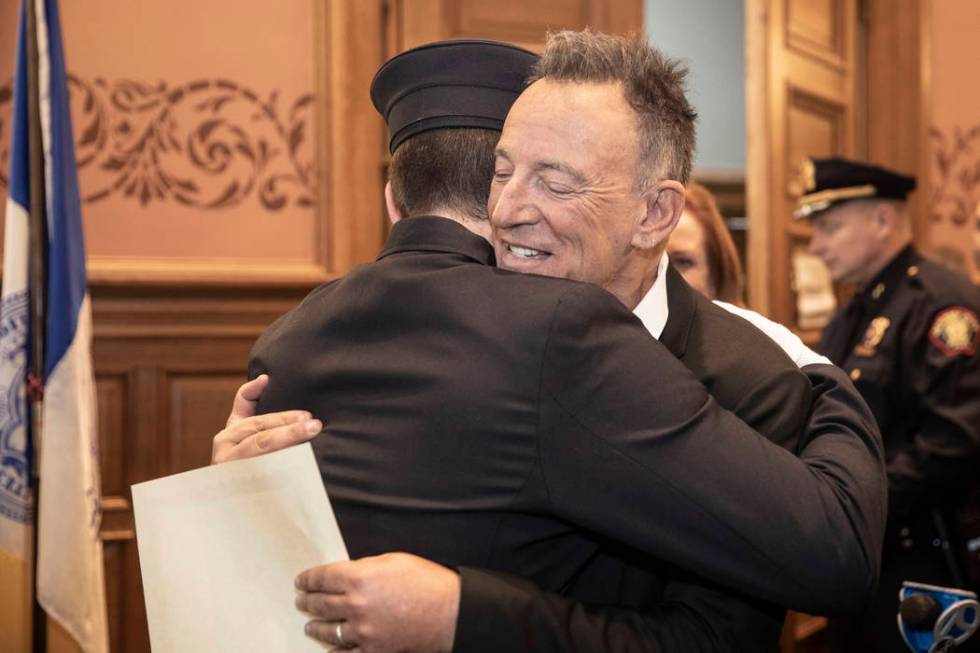 In this photo provided by the Jersey City Mayor's Office, Bruce Springsteen hugs his son Sam Sp ...