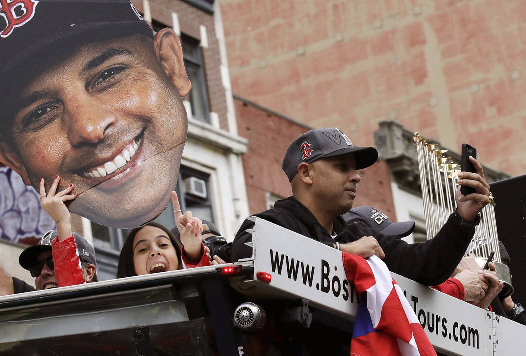 Boston Red Sox manager Alex Cora takes a photo as his daughter Camila, left, holds a cutout pho ...