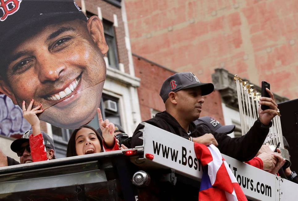 Boston Red Sox manager Alex Cora takes a photo as his daughter Camila, left, holds a cutout pho ...