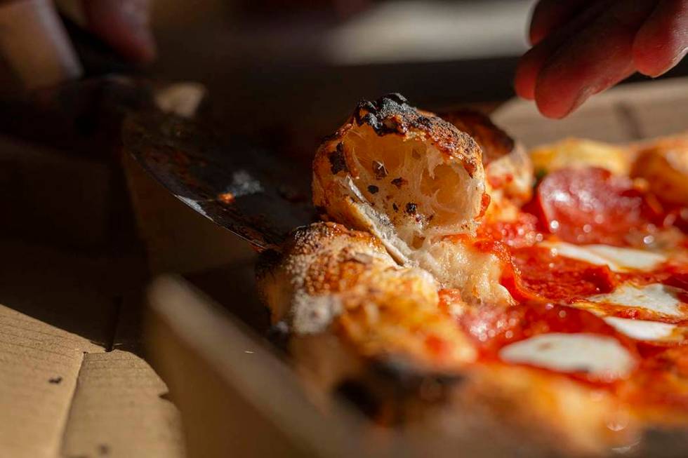 Chef Bartosz Wawrzyszak, owner of the Custom Pizza Truck, shows the thickness of his prized dou ...