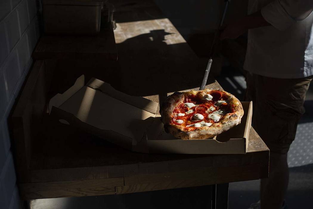 Chef Bartosz Wawrzyszak, owner of the Custom Pizza Truck, prepares a salami gorgonzola pizza fr ...