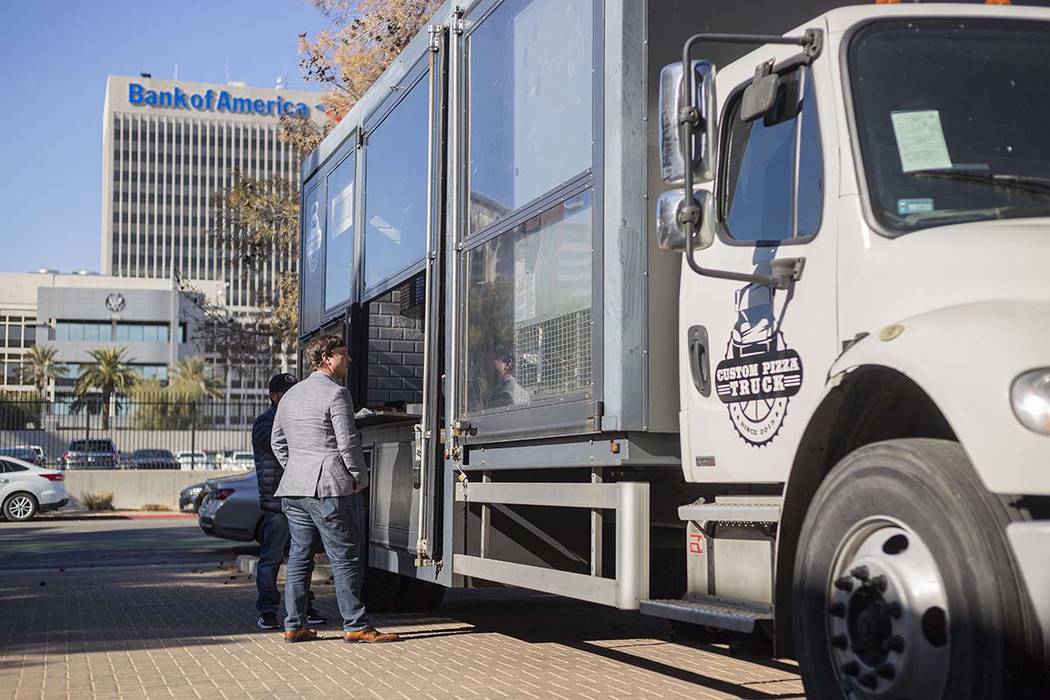 Elliott Schlottman of Las Vegas orders from Custom Pizza Truck, parked on 317 S. Sixth St., in ...