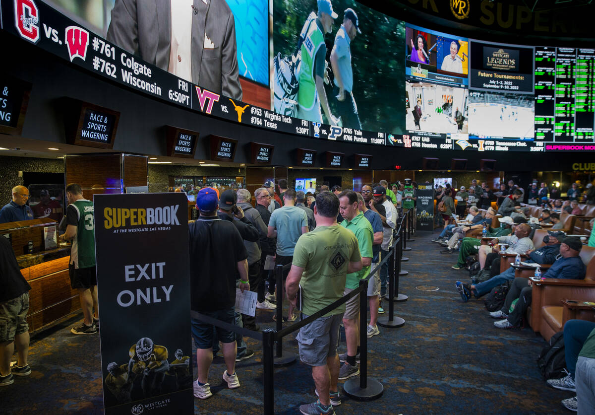 Bettors stand in line to put their money down as March Madness begins in the Superbook at Westg ...