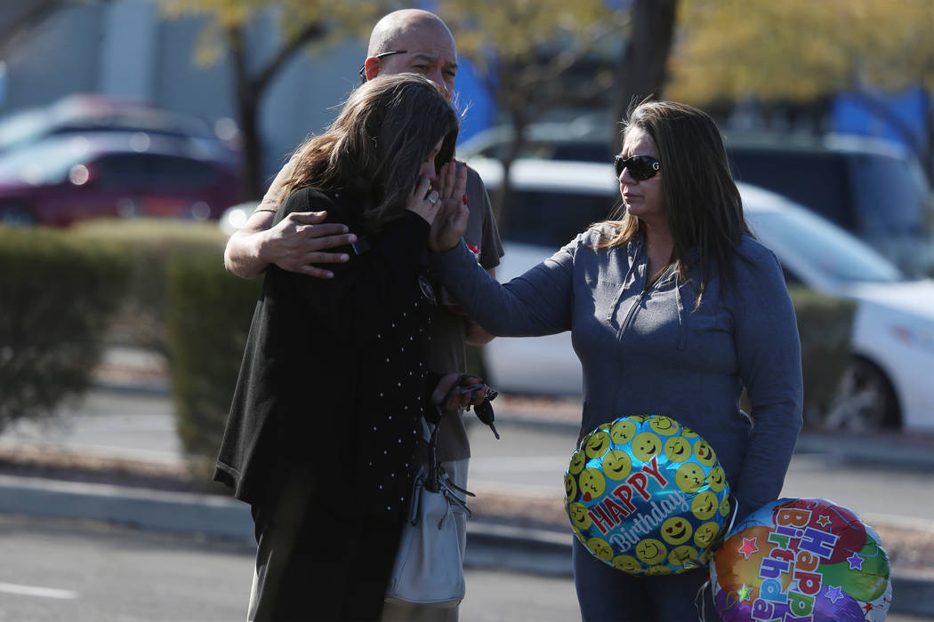 People embrace after leaving the scene of an officer-involved shooting that occurred in the 690 ...