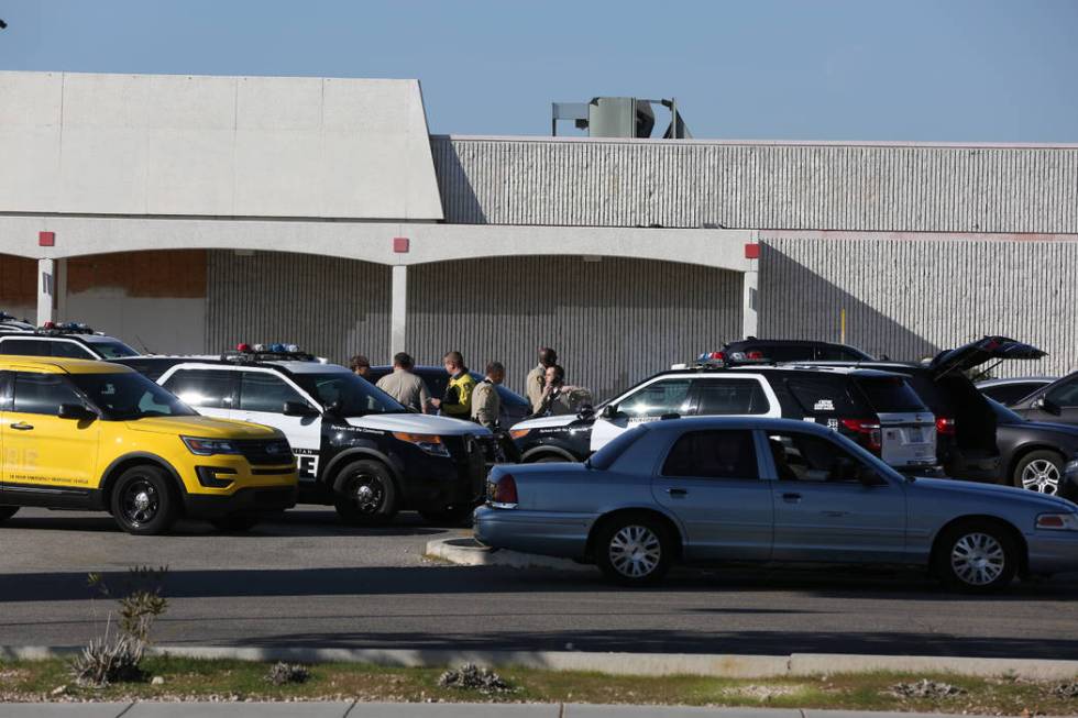 Las Vegas Metropolitan Police muster near an open field barricade with shooting suspect on Rain ...