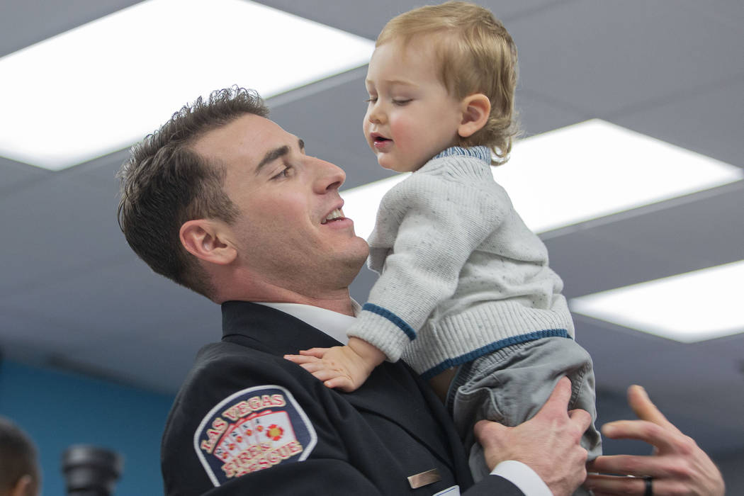 Las Vegas Fire and Rescue firefighter Justin Field holds his son, 1-year-old Levi Field, during ...