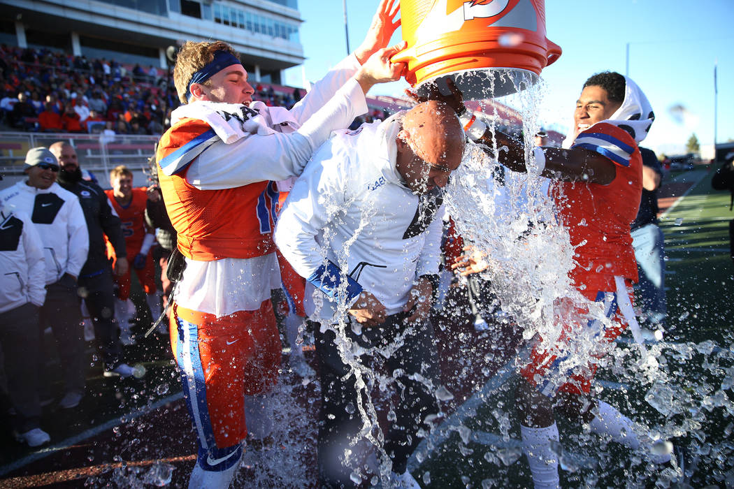 Bishop Gorman's head football coach Kenny Sanchez, center, gets a Gatorade (water) shower by hi ...