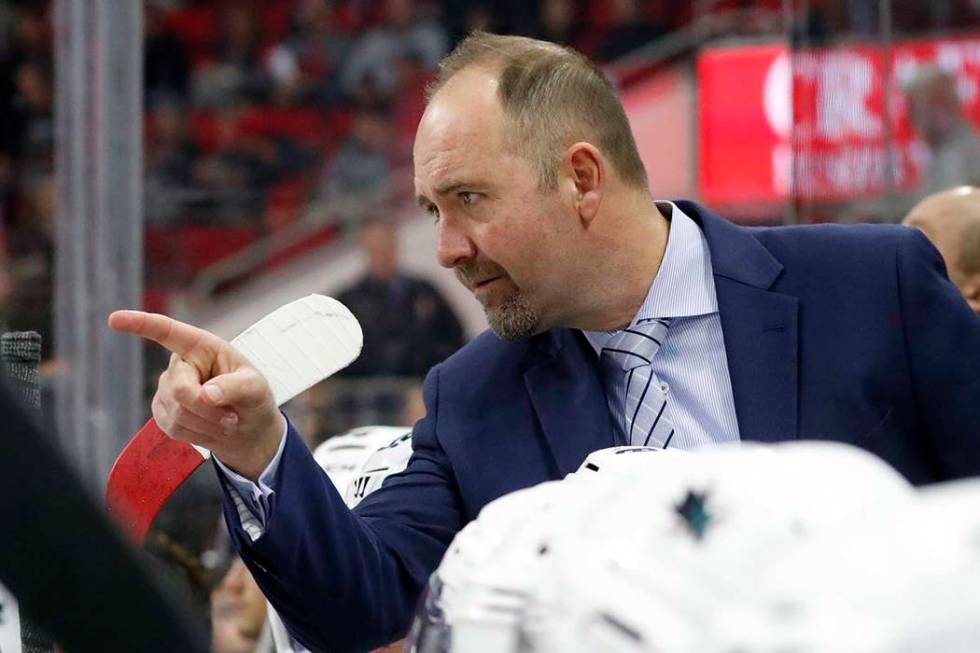 San Jose Sharks' head coach Peter DeBoer confers with an official during an NHL hockey game aga ...