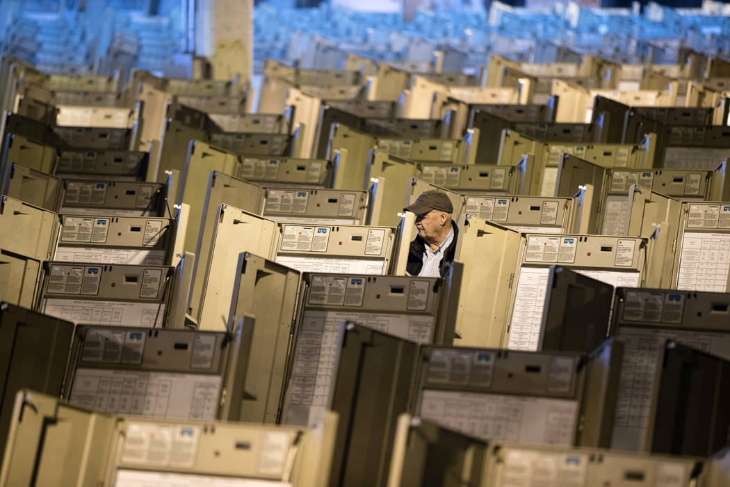 FILE- In this Oct. 14, 2016, file photo, a technician works to prepare voting machines to be us ...