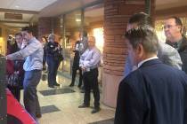 A crowd gathers around monitors at the Clark County Government Center that list the candidates ...