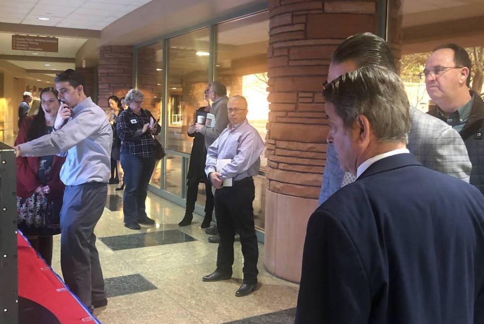 A crowd gathers around monitors at the Clark County Government Center that list the candidates ...