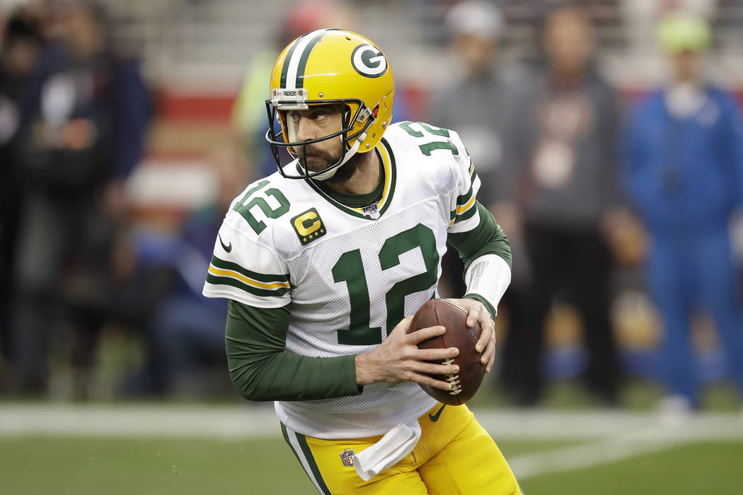 Green Bay Packers quarterback Aaron Rodgers (12) rolls out during the first half of the NFL NFC ...
