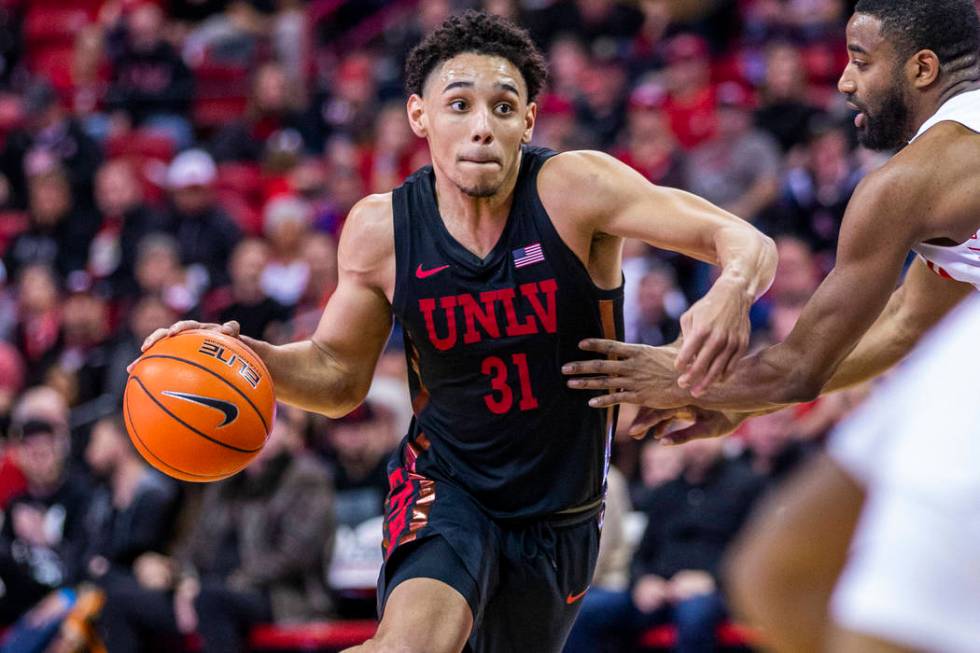 UNLV Rebels guard Marvin Coleman (31, center) drives the lane versus New Mexico Lobos guard JaQ ...