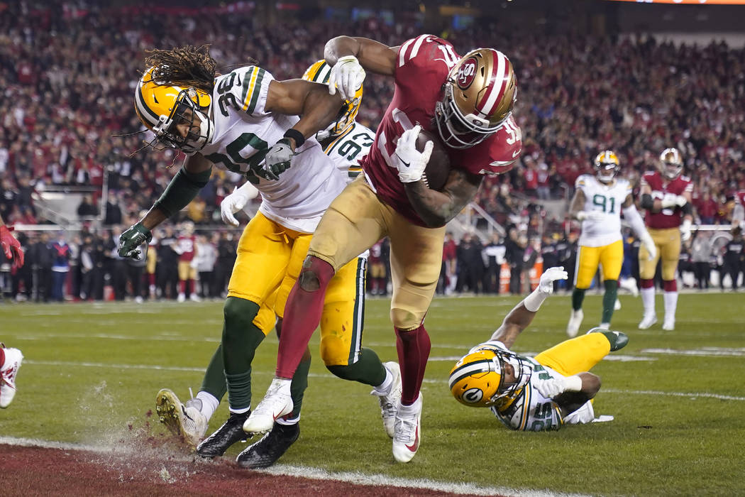 San Francisco 49ers running back Raheem Mostert, center right, scores a touchdown next to Green ...