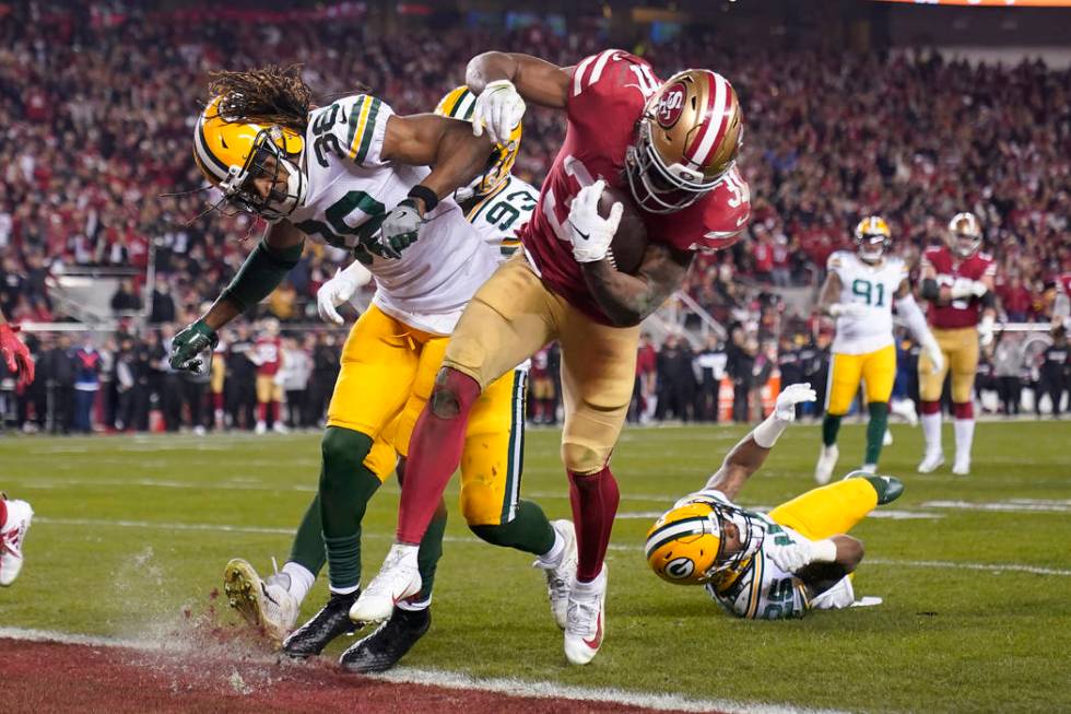 San Francisco 49ers running back Raheem Mostert, center right, scores a touchdown next to Green ...