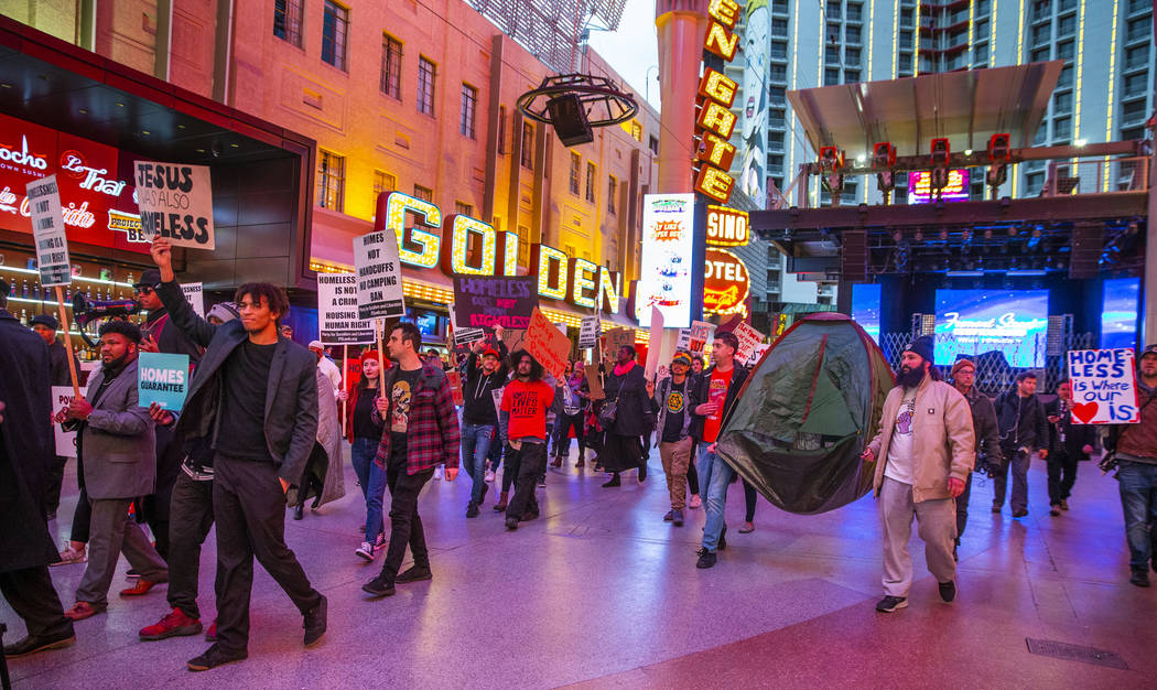 Local activists march through the Fremont Experience following a rally at the Las Vegas City Ha ...