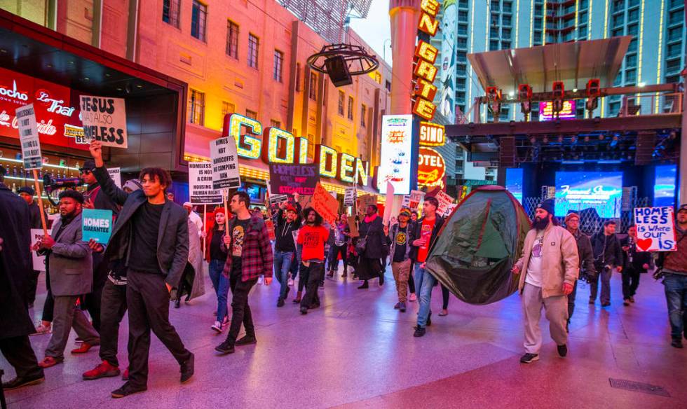 Local activists march through the Fremont Experience following a rally at the Las Vegas City Ha ...