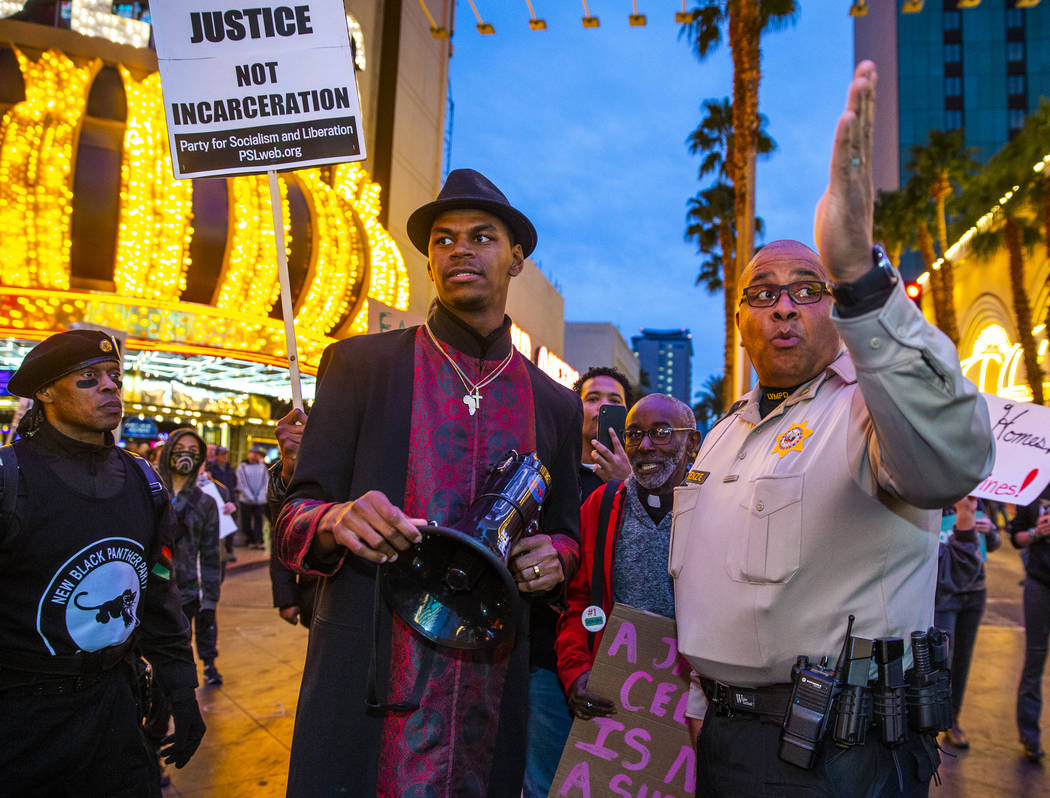 Minister Stretch Sanders Local, center, confers with Metro Lt. McKenzie as activists block Casi ...