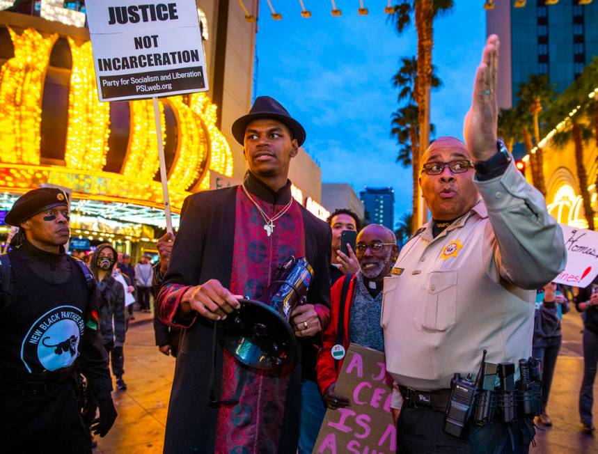 Minister Stretch Sanders Local, center, confers with Metro Lt. McKenzie as activists block Casi ...