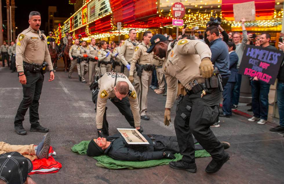 Las Vegas Metropolitan Police officers move in to arrest local activists blocking Casino Center ...