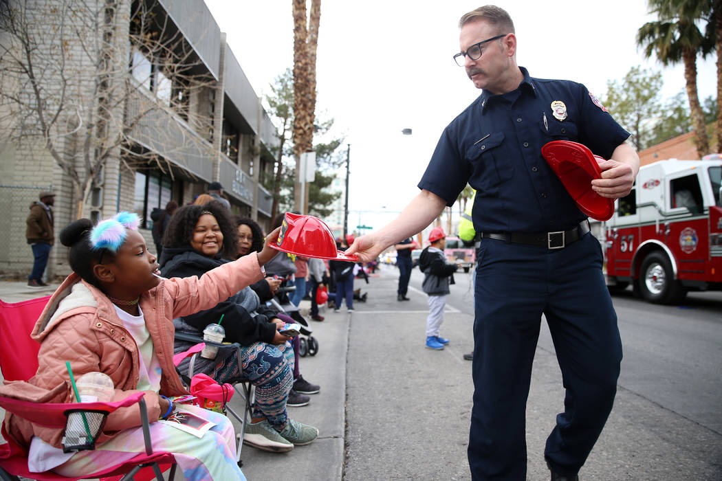 North Las Vegas Fire Department Captain Steve Wells, right, hands out a firefighter hat to Taja ...