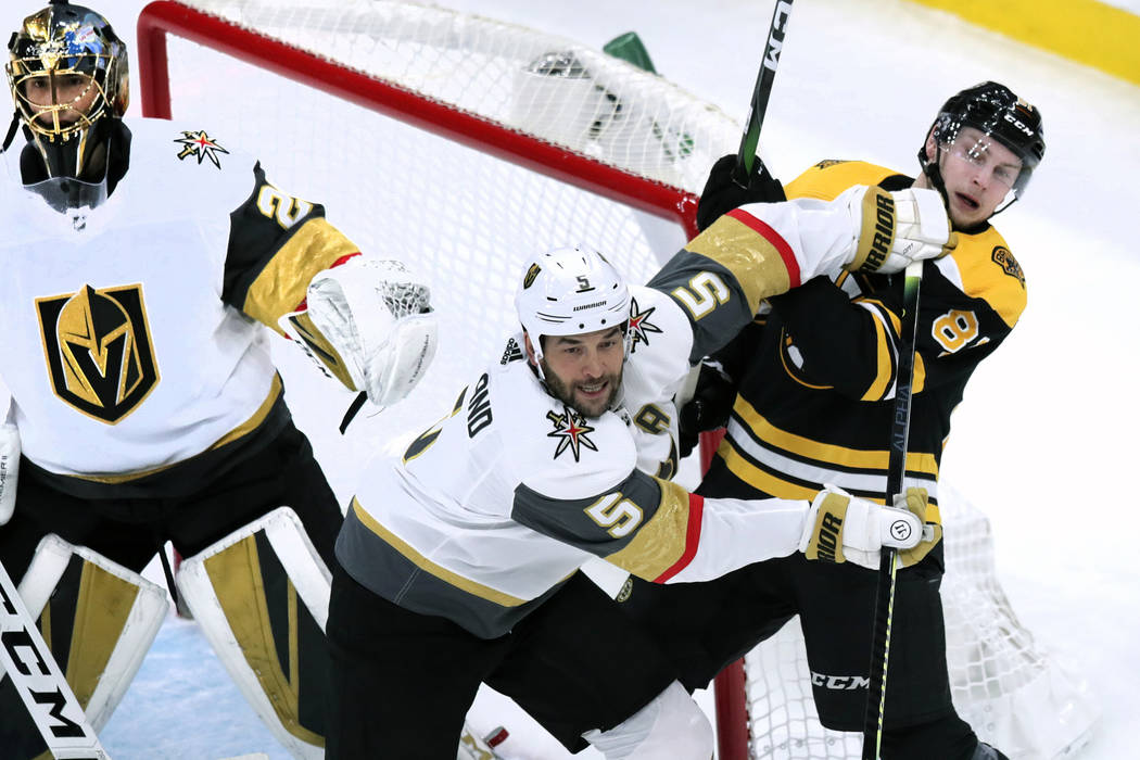 Vegas Golden Knights defenseman Deryk Engelland (5) tries to clear Boston Bruins Anton Blidh, r ...