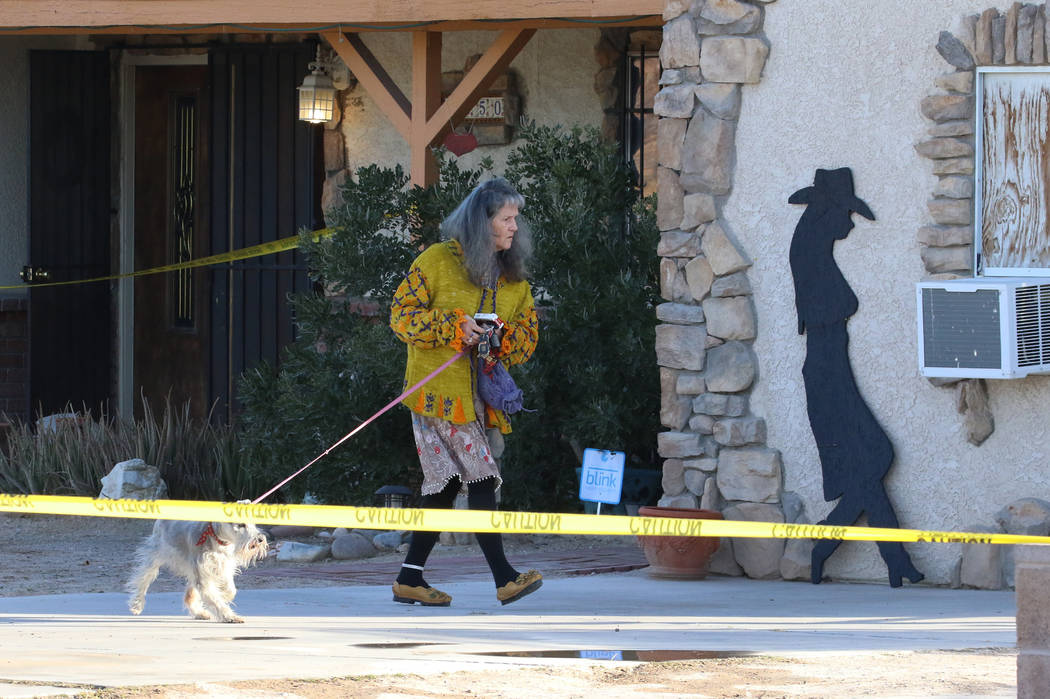 A woman and her dog leave the house where a person died in a shed fire at 2350 Lincoln Road on ...