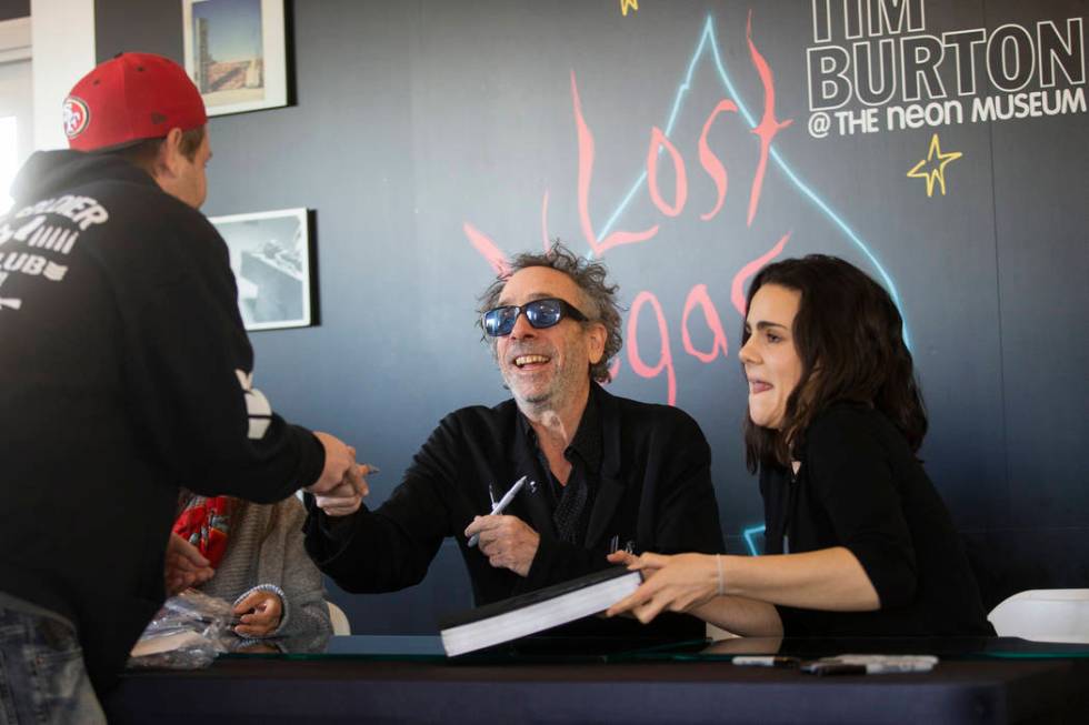 Director and artist Tim Burton, middle, greets fans during a book signing promoting his exhibit ...