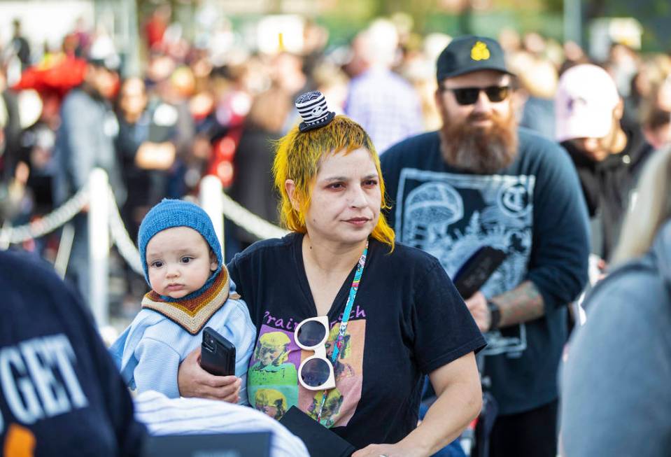 Julie Crowell, from Orange County, Calif., holds her son Jules, 8 months, as they wait in line ...