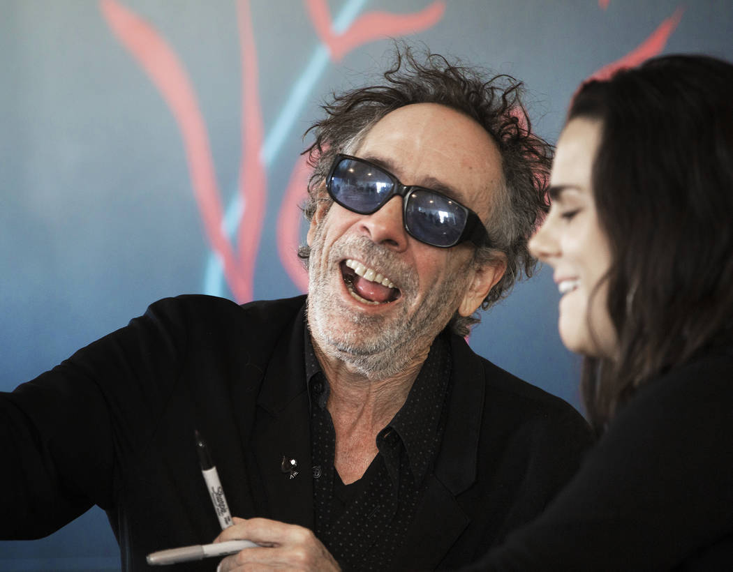 Director and artist Tim Burton, left, greets fans during a book signing promoting his exhibitio ...
