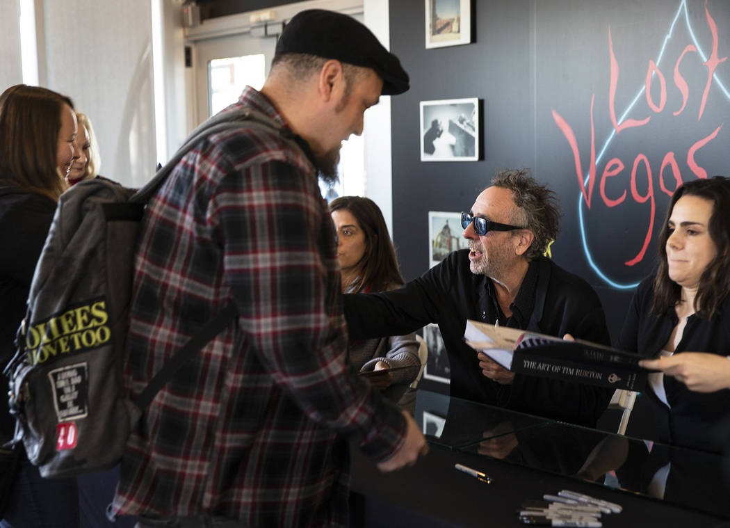 Director and artist Tim Burton, second from right, greets fans during a book signing promoting ...