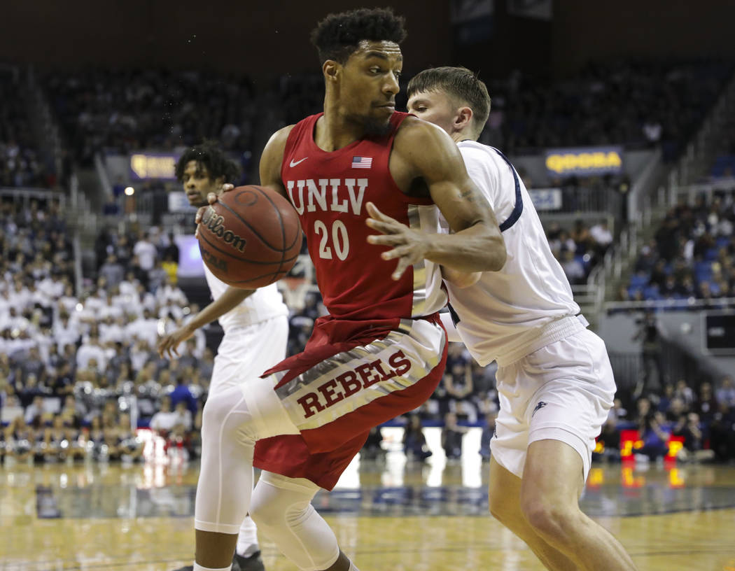 UNLV Rebels' Nick Blair (20) moves the ball around a UNR defender during the first half of a ba ...