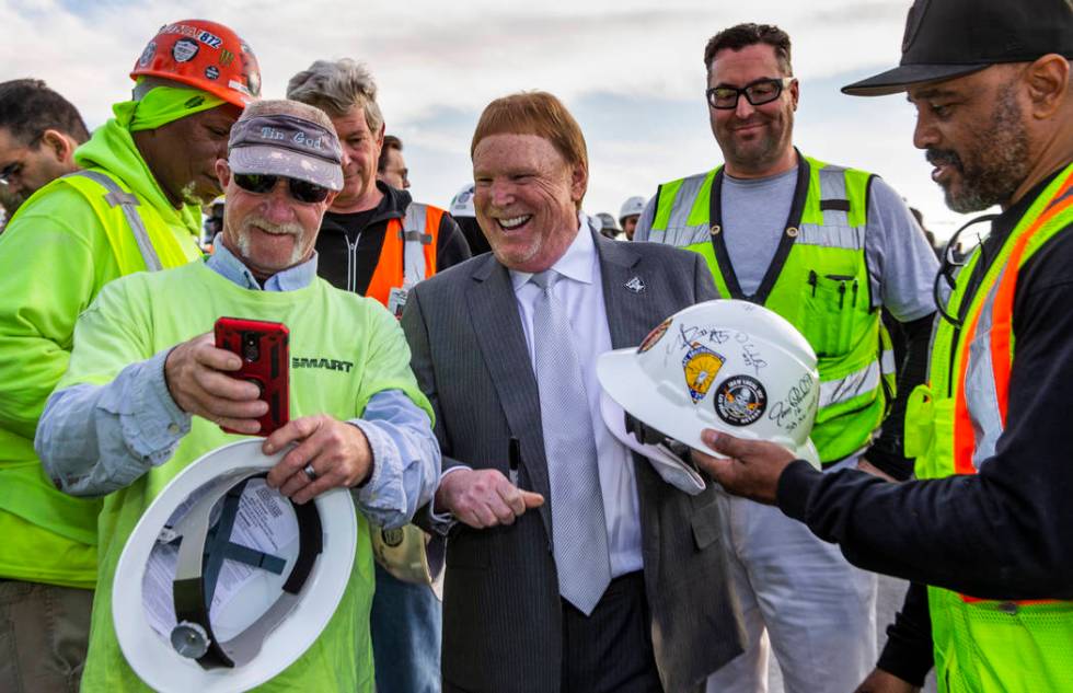 Construction worker David Geene, left, attempts to take a selfie with Raiders owner Mark Davis ...