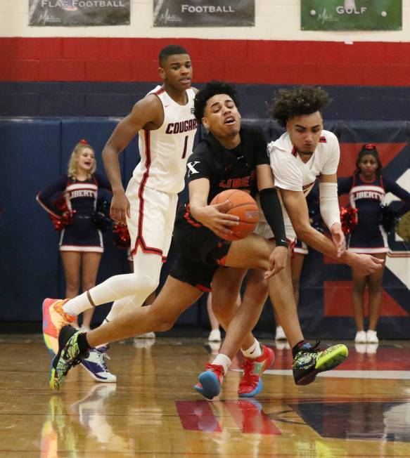 Coronado High's guard Jaden Hardy (1) watches as Liberty High's guard Julian Strawther, center, ...