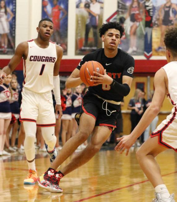 Coronado High's Jaden Hardy (1) watches as Liberty High's guard Julian Strawther (0) tries to p ...