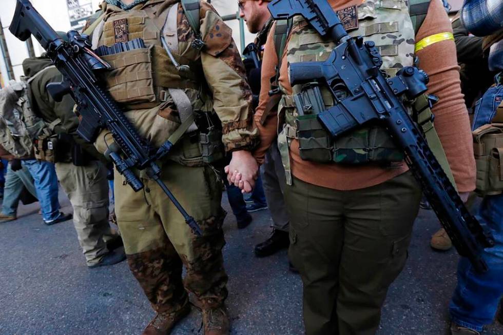 Demonstrators stand outside a security zone before a pro gun rally, Monday, Jan. 20, 2020, in R ...