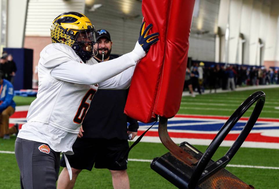 Michigan's Joshua Uche participates in drills while Detroit Lions coach Matt Patricia watches a ...