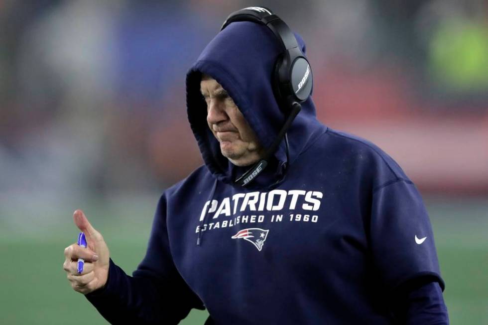 New England Patriots head coach Bill Belichick gives a signal to the team from the sideline in ...