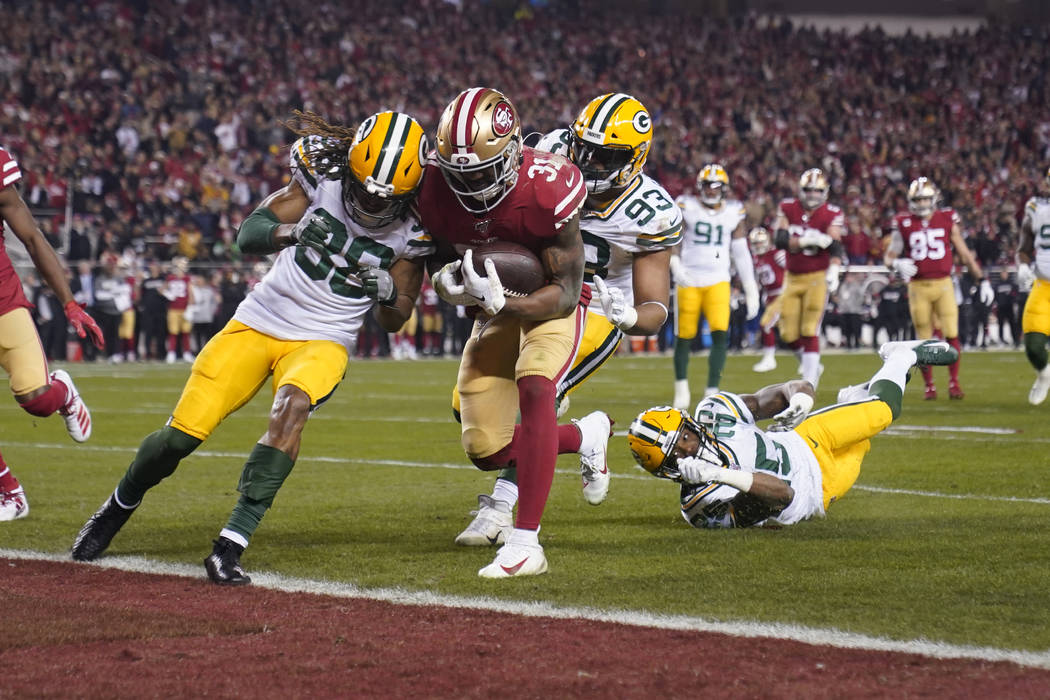 San Francisco 49ers running back Raheem Mostert, center, scores a touchdown next to Green Bay P ...