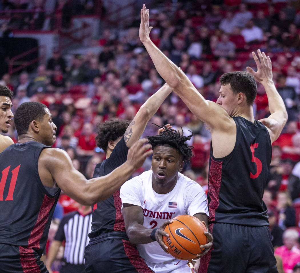 UNLV Rebels forward Donnie Tillman (2, center) looks for a pass under tight defense by San Dieg ...